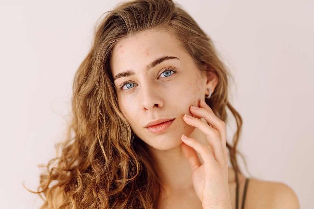 Young woman with curly hair and blue eyes.