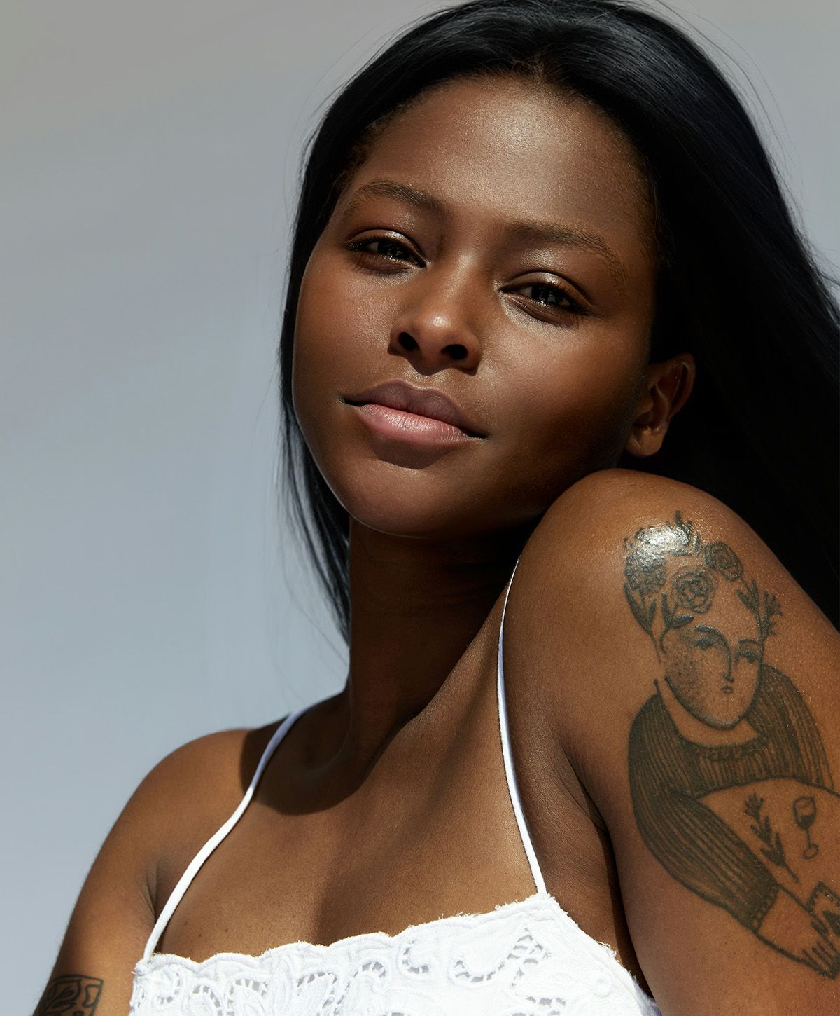 Portrait of a woman with a tattooed arm.