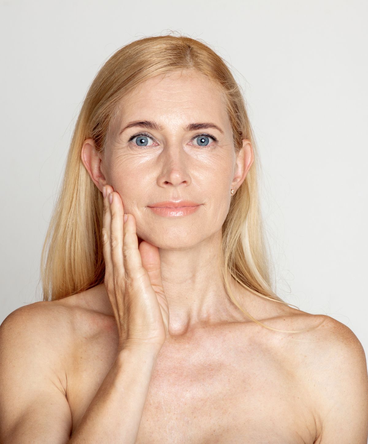 acne treatment patient model smiling and touching her face