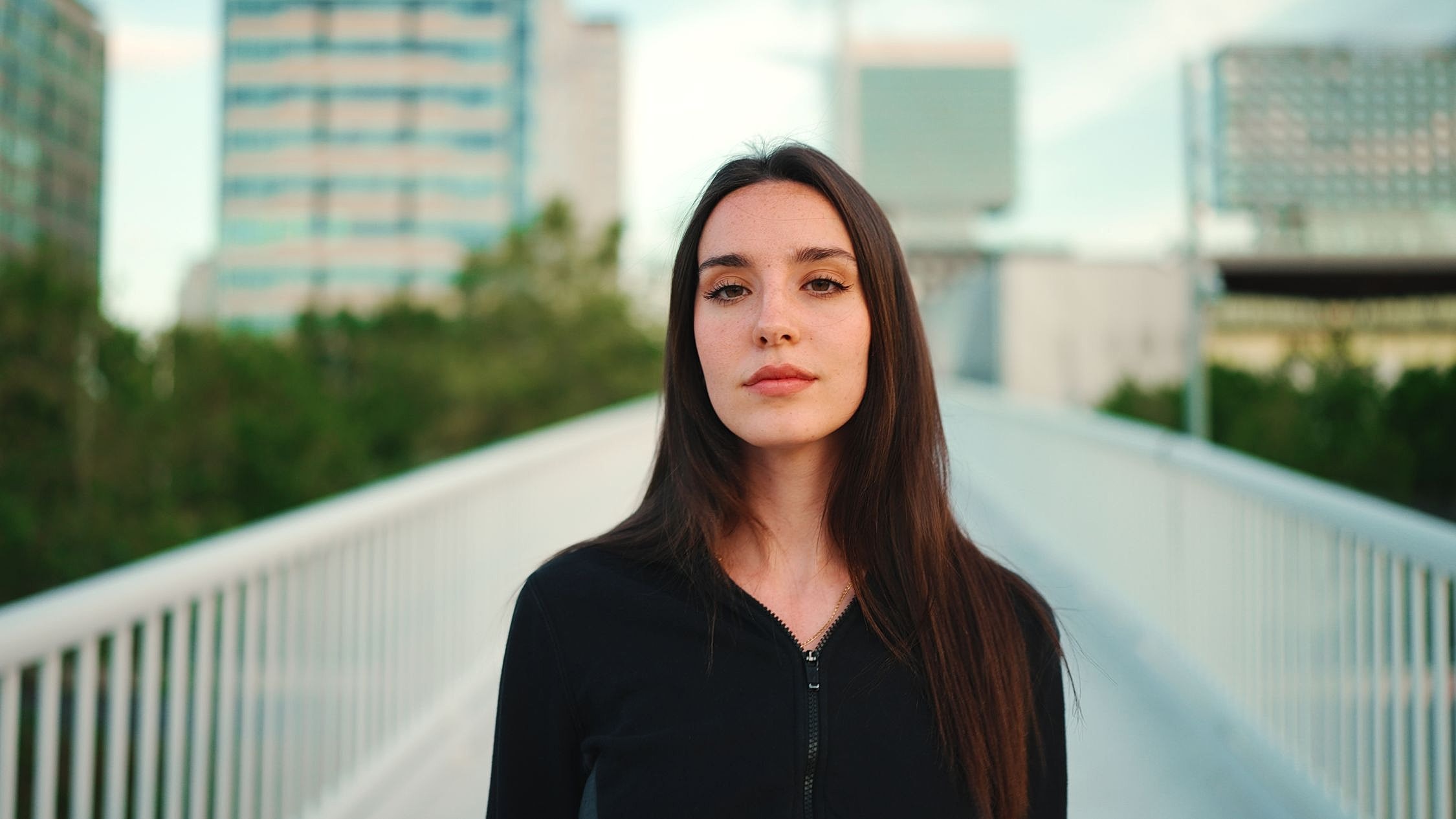 Young woman standing on urban walkway.