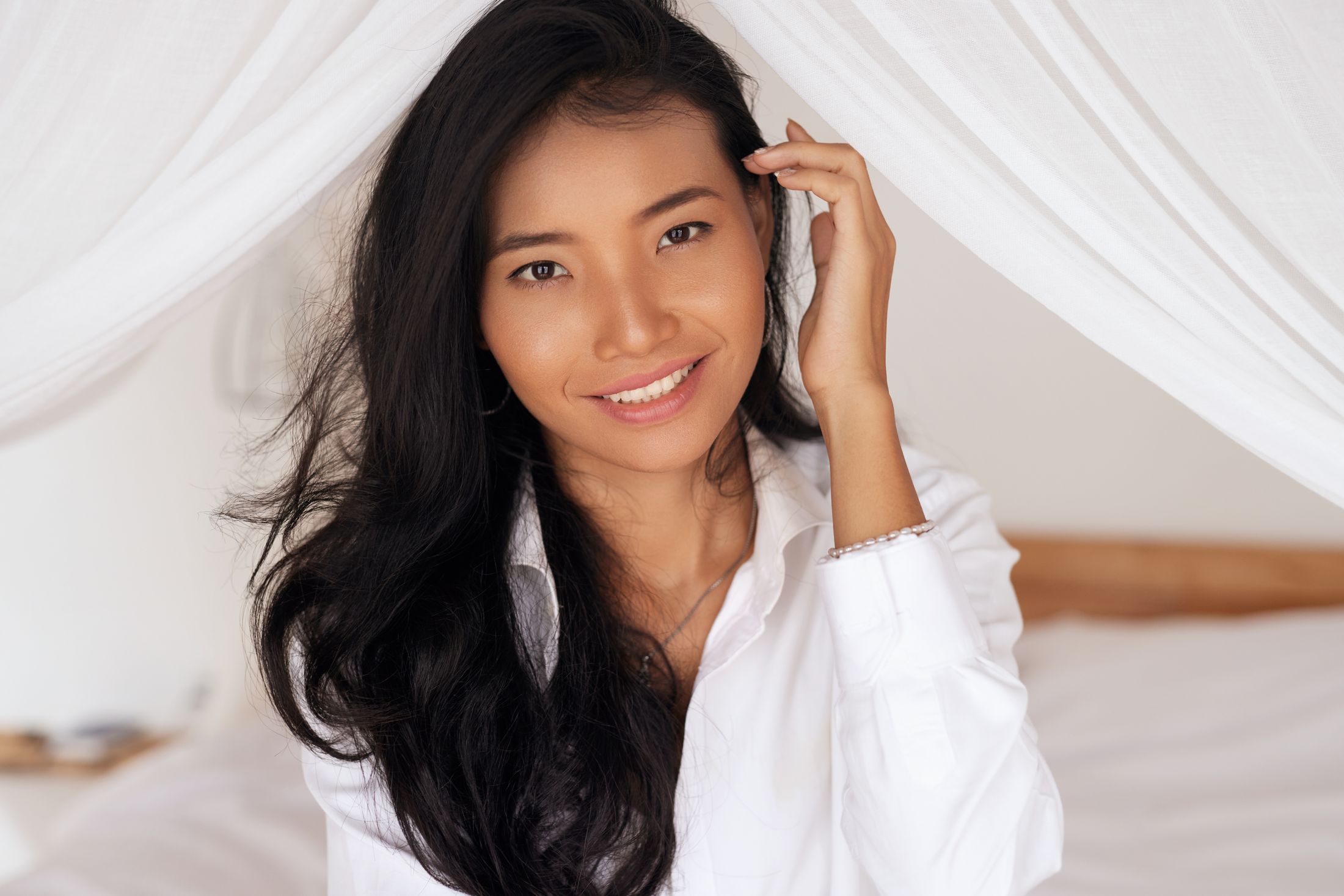 dermaplaning patient model in a white jacket putting her hair behind her ear