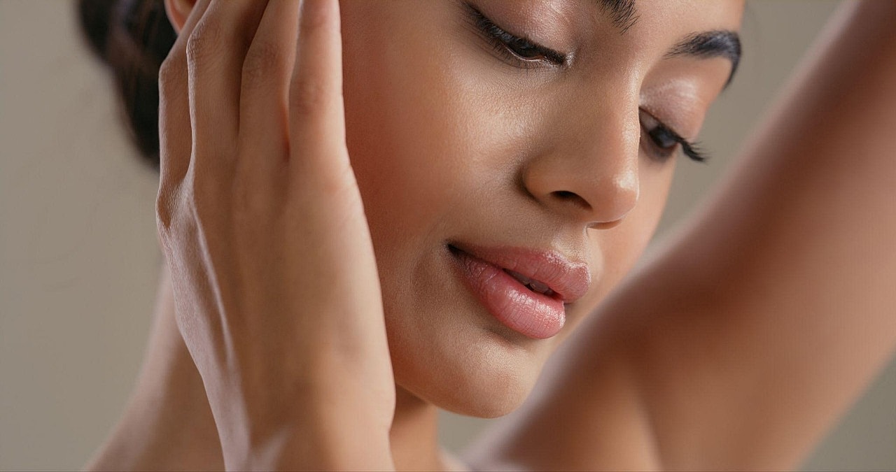 Professional Skincare in Bellevue for Melanin-Rich Skin-up of woman with gentle expression and hands.